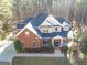 Traditional brick home showcasing a well-manicured front yard with a welcoming front porch at 684 Brooks Woolsey Rd, Brooks, GA 30205