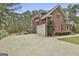 Side view of a brick home featuring an attached two-car garage and a spacious driveway at 684 Brooks Woolsey Rd, Brooks, GA 30205