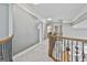 Upstairs hallway featuring wood and iron railing, gray walls, and carpeted floor at 684 Brooks Woolsey Rd, Brooks, GA 30205
