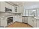 Bright kitchen features white cabinets, stainless steel appliances, granite countertops, and tile backsplash at 684 Brooks Woolsey Rd, Brooks, GA 30205
