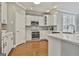 Bright kitchen with white cabinets, quartz countertops, and stainless steel appliances at 684 Brooks Woolsey Rd, Brooks, GA 30205