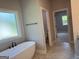 Bright bathroom with a freestanding bathtub next to a window, and tiled floors at 152 Wet Wood Dr # 10, Fairburn, GA 30213