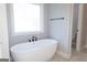 Sleek freestanding bathtub with black hardware and a window with natural light and grey tile flooring at 152 Wet Wood Dr # 10, Fairburn, GA 30213