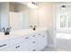 Bright bathroom features double vanity, white cabinets, black fixtures, and leads to light-filled bedroom at 152 Wet Wood Dr # 10, Fairburn, GA 30213