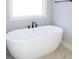 Bright bathroom featuring a standalone tub with modern fixtures and natural light at 152 Wet Wood Dr # 10, Fairburn, GA 30213