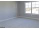 Serene bedroom with plush carpeting, neutral paint, and large window overlooking the backyard at 152 Wet Wood Dr # 10, Fairburn, GA 30213