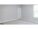 Light gray bedroom features neutral carpet, white trim and door, with a window view at 152 Wet Wood Dr # 10, Fairburn, GA 30213