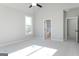 This bedroom features neutral carpet, a ceiling fan, and a door leading to a bright bathroom at 152 Wet Wood Dr # 10, Fairburn, GA 30213