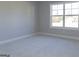 Serene bedroom featuring neutral carpet, light gray walls, a large window, and minimalist design at 152 Wet Wood Dr # 10, Fairburn, GA 30213