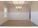 Elegant dining room featuring wainscoting, a modern chandelier, hardwood floors, and a large window at 152 Wet Wood Dr # 10, Fairburn, GA 30213