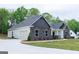 A beautifully crafted single-story home showcasing stone and siding details, with an attached garage and concrete driveway at 152 Wet Wood Dr # 10, Fairburn, GA 30213