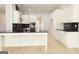 Modern kitchen boasts white cabinets, black hardware, black countertops and herringbone backsplash with light wood flooring at 152 Wet Wood Dr # 10, Fairburn, GA 30213