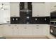 Modern kitchen with white cabinets and black backsplash at 152 Wet Wood Dr # 10, Fairburn, GA 30213