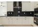 Well-equipped kitchen with white cabinets, stainless steel appliances, and black herringbone backsplash at 152 Wet Wood Dr # 10, Fairburn, GA 30213