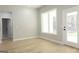 Bright living room featuring light wood floors, a large window, and a white door leading to the outside at 152 Wet Wood Dr # 10, Fairburn, GA 30213