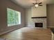 Bright living room featuring a stone fireplace, high ceilings with ceiling fan, and natural light from a large window at 152 Wet Wood Dr # 10, Fairburn, GA 30213