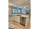 Kitchen island with granite countertops and a stainless steel dishwasher opening to the living room with a fireplace at 5096 Cumberland Ct, Villa Rica, GA 30180