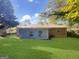 Spacious backyard with lush green grass surrounding the blue and brick exterior at 828 Pinevalley Dr, Forest Park, GA 30297
