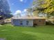 Expansive backyard showcasing a blend of painted siding and brick, complemented by a lush green lawn and mature trees at 828 Pinevalley Dr, Forest Park, GA 30297