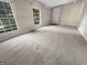 Bright bedroom with soft neutral carpet, two windows, and a door to the hall at 828 Pinevalley Dr, Forest Park, GA 30297