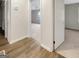 Hallway featuring wood look flooring and view into bedroom with neutral carpet at 828 Pinevalley Dr, Forest Park, GA 30297
