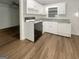 Cozy kitchen featuring white cabinets, laminate countertops, and a black and white range at 828 Pinevalley Dr, Forest Park, GA 30297