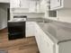 Functional kitchen featuring an electric range, white cabinets and gray countertop at 828 Pinevalley Dr, Forest Park, GA 30297