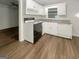 Compact kitchen with white cabinets, black oven, and wood-look vinyl flooring at 828 Pinevalley Dr, Forest Park, GA 30297