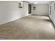 Spacious living room with neutral carpet, white painted brick walls, and natural light from the windows at 828 Pinevalley Dr, Forest Park, GA 30297