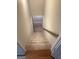 Carpeted stairs with wood trim, hardwood at bottom, and railing lead to lower level at 7193 Tara Dr, Villa Rica, GA 30180