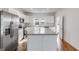Modern kitchen with stainless steel appliances, white cabinets, and granite countertops on an island at 734 W College St, Bowdon, GA 30108