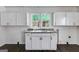 This kitchen has lots of counter space and cabinet space with updated floors and a window view at 734 W College St, Bowdon, GA 30108