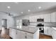Bright kitchen with stainless steel appliances, white cabinets, a large island, and hardwood floors at 734 W College St, Bowdon, GA 30108