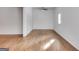 Spacious living room featuring beautiful hardwood floors, white walls, and bright natural light at 734 W College St, Bowdon, GA 30108