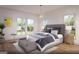 Bright bedroom with a padded headboard, hardwood floors, light gray quilt and lots of natural light from the large windows at 1000 Blair Ln # 102, Peachtree City, GA 30269