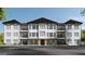 Inviting three story condo building featuring balconies, brick accents and mature landscaping at 1000 Blair Ln # 102, Peachtree City, GA 30269