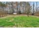 Large grassy backyard with mature trees and a storage shed, offering plenty of space for outdoor activities at 130 Nicki Ct, Hampton, GA 30228