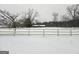 Scenic winter view of property with snow-covered ground and a charming farmhouse in the background at 1024 Bethany Rd, Covington, GA 30016