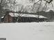 Quaint snow scene featuring the home's facade during winter, with the roof and yard covered in white at 1024 Bethany Rd, Covington, GA 30016