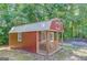 Red storage building with porch in wooded backyard at 399 Towler, Loganville, GA 30052