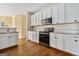 Bright kitchen with white cabinets, stainless steel appliances and hardwood floors at 625 Aya Cir, Loganville, GA 30052