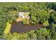 Aerial view showcases the home and the pond surrounded by a lush tree canopy at 50 Persian Pl, Whitesburg, GA 30185