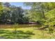 Backyard with a small bush, shade trees, and lakefront access at 50 Persian Pl, Whitesburg, GA 30185