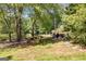Large, grassy backyard with mature trees and a serene pond at 50 Persian Pl, Whitesburg, GA 30185