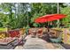 Well-appointed deck with outdoor furniture, fire pit, and umbrella for enjoying peaceful surroundings at 50 Persian Pl, Whitesburg, GA 30185