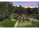 An attractive home at dusk features a manicured lawn and mature trees, offering a serene and private setting at 50 Persian Pl, Whitesburg, GA 30185