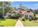 A charming two-story home features a manicured lawn with mature trees, on a sunny day at 50 Persian Pl, Whitesburg, GA 30185