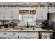 Kitchen counter with granite countertops, stainless steel sink, and classic white cabinetry at 50 Persian Pl, Whitesburg, GA 30185