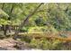 Picturesque pond featuring tree arching over water with benches nearby at 50 Persian Pl, Whitesburg, GA 30185