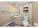 Well-lit bathroom featuring a vanity with a mirror, toilet, and storage shelves at 6 Alston Ne Pl, Atlanta, GA 30324